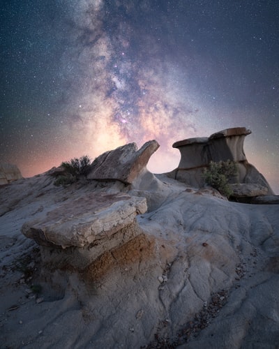 brown rock formation under starry night